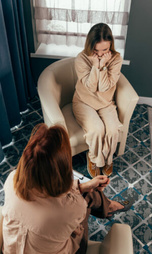 Mental health, counseling and therapy patient talking of problem, health expert listening. Therapist comforting a patient. Psychotherapy session, woman talking to his psychologist in the studio.